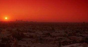 Movie still from “Night of the Comet” (1984), directed by Thom Eberhardt – A red sky over a city at sunset; Extreme Wide shot, High angle