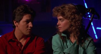 Movie still from “Night of the Comet” (1984), directed by Thom Eberhardt – A man and a woman sitting next to each other; Close Up shot, Low angle