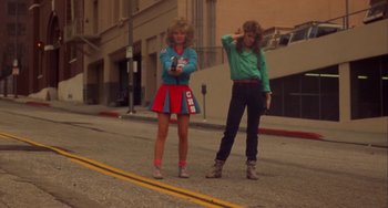 Movie still from “Night of the Comet” (1984), directed by Thom Eberhardt – Two women standing on the side of the street; Wide shot, Low angle