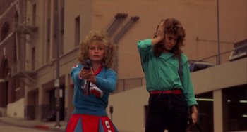 Movie still from “Night of the Comet” (1984), directed by Thom Eberhardt – Two young women are standing on the sidewalk; Medium shot, Low angle
