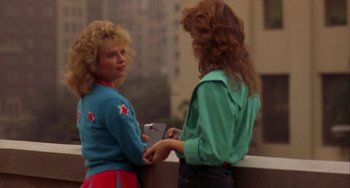 Movie still from “Night of the Comet” (1984), directed by Thom Eberhardt – Two women standing next to each other on a bridge; Medium shot, Over the shoulder angle