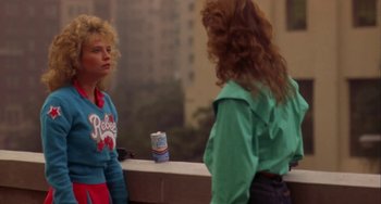 Movie still from “Night of the Comet” (1984), directed by Thom Eberhardt – Two women standing in front of each other in front of a mirror; Medium shot, Over the shoulder angle