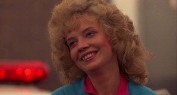 Movie still from “Night of the Comet” (1984), directed by Thom Eberhardt – A person with blonde curly hair; Close Up shot, Low angle