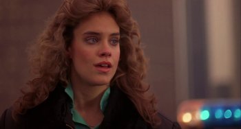 Movie still from “Night of the Comet” (1984), directed by Thom Eberhardt – A person with long curly hair; Close Up shot, Over the shoulder angle