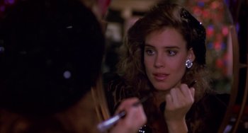 Movie still from “Night of the Comet” (1984), directed by Thom Eberhardt – A woman is looking at the camera while holding a pen; Close Up shot, Over the shoulder angle