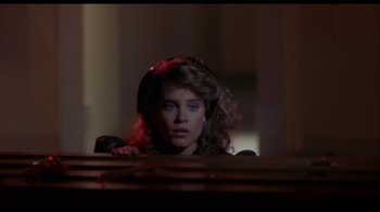 Movie still from “Night of the Comet” (1984), directed by Thom Eberhardt – A young woman sitting at a table in front of a mirror; Close Up shot, Low angle
