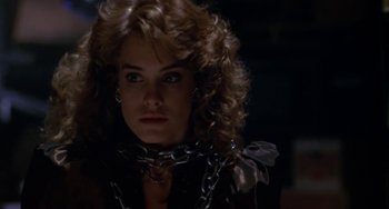 Movie still from “Night of the Comet” (1984), directed by Thom Eberhardt – A person wearing a chain around her neck; Close Up shot, Low angle