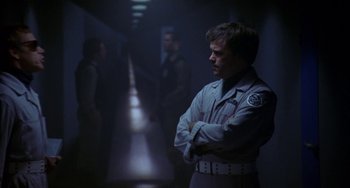 Movie still from “Night of the Comet” (1984), directed by Thom Eberhardt – A group of men standing next to each other in a hallway; Medium shot, Low angle