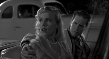 Movie still from “Night of the Creeps” (1986), directed by Fred Dekker – A man and a woman standing next to each other in front of a car; Close Up shot, Low angle