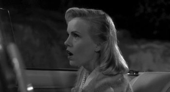 Movie still from “Night of the Creeps” (1986), directed by Fred Dekker – A black - and - white photo of a woman in a car; Close Up shot, High angle