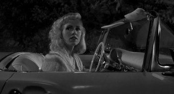 Movie still from “Night of the Creeps” (1986), directed by Fred Dekker – A black and white photo of a woman driving a car; Close Up shot, Low angle