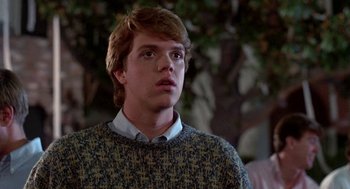 Movie still from “Night of the Creeps” (1986), directed by Fred Dekker – A young man wearing a sweater looking to his left; Close Up shot, Low angle