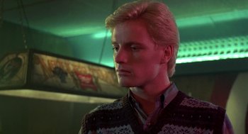 Movie still from “Night of the Creeps” (1986), directed by Fred Dekker – A man with blonde hair wearing a sweater; Close Up shot, Low angle