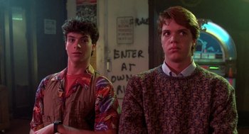 Movie still from “Night of the Creeps” (1986), directed by Fred Dekker – Two young men standing next to each other in front of graffiti; Medium shot, Low angle