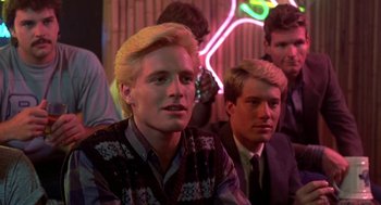 Movie still from “Night of the Creeps” (1986), directed by Fred Dekker – A group of young men sitting next to each other in a room; Close Up shot, Over the shoulder angle