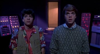 Movie still from “Night of the Creeps” (1986), directed by Fred Dekker – A couple of men standing next to each other in a room; Medium shot, Low angle