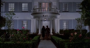 Movie still from “Night of the Creeps” (1986), directed by Fred Dekker – Two people are standing in front of a building; Wide shot, Low angle