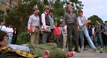 Movie still from “Night of the Creeps” (1986), directed by Fred Dekker – A group of young men standing next to each other on a sidewalk; Wide shot, High angle