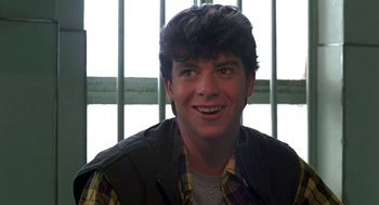 Movie still from “Night of the Creeps” (1986), directed by Fred Dekker – A young man smiling for the camera in front of a window; Close Up shot, Low angle