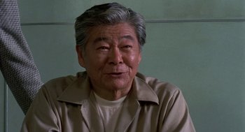 Movie still from “Night of the Creeps” (1986), directed by Fred Dekker – An older man wearing a tan shirt and a tan jacket; Close Up shot, Low angle