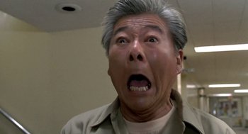 Movie still from “Night of the Creeps” (1986), directed by Fred Dekker – An older man with grey hair is looking surprised; Close Up shot, Low angle