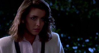 Movie still from “Night of the Creeps” (1986), directed by Fred Dekker – A young woman in a white shirt and a black tie; Close Up shot, Over the shoulder angle