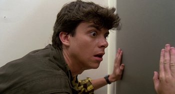 Movie still from “Night of the Creeps” (1986), directed by Fred Dekker – A young man with a surprised look on his face; Close Up shot, Low angle