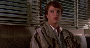 Movie still from “Night of the Creeps” (1986), directed by Fred Dekker – A man in a jacket and a tie in front of a window; Close Up shot, Over the shoulder angle