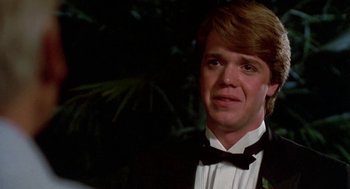 Movie still from “Night of the Creeps” (1986), directed by Fred Dekker – A man in a tuxedo standing in front of a tree; Close Up shot, Over the shoulder angle