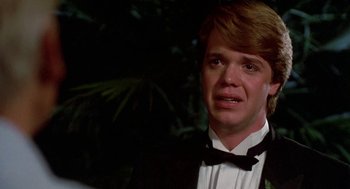 Movie still from “Night of the Creeps” (1986), directed by Fred Dekker – A man in a suit and bow tie crying in front of a tree; Close Up shot, Over the shoulder angle