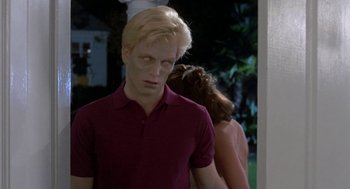 Movie still from “Night of the Creeps” (1986), directed by Fred Dekker – A man with blonde hair wearing a maroon shirt; Medium shot, Over the shoulder angle
