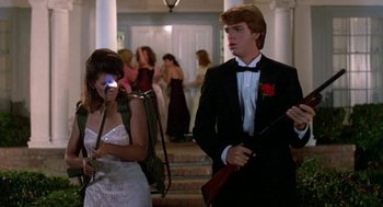 Movie still from “Night of the Creeps” (1986), directed by Fred Dekker – A man in a tuxedo standing next to a woman in a white dress; Medium shot, Low angle