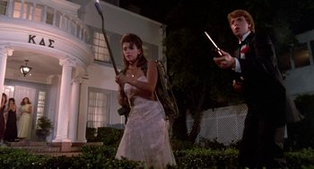 Movie still from “Night of the Creeps” (1986), directed by Fred Dekker – A woman in a white dress holding a baseball bat; Medium shot, Low angle