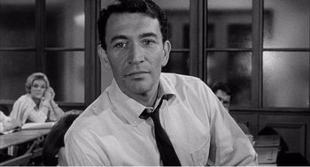 Movie still from “Night of the Eagle” (1962), directed by Sidney Hayers – Black and white photograph of a man wearing a shirt and tie; Close Up shot, High angle
