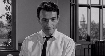 Movie still from “Night of the Eagle” (1962), directed by Sidney Hayers – Black and white photograph of a man wearing a shirt and tie; Close Up shot, Low angle
