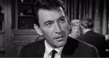 Movie still from “Night of the Eagle” (1962), directed by Sidney Hayers – Black and white photograph of a man in a suit and tie; Close Up shot, High angle