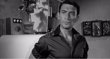 Movie still from “Night of the Eagle” (1962), directed by Sidney Hayers – Black and white photograph of a man in a room; Close Up shot, Low angle