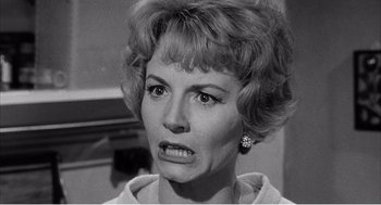 Movie still from “Night of the Eagle” (1962), directed by Sidney Hayers – An old photo of a woman with a frowning look on her face; Close Up shot, Over the shoulder angle