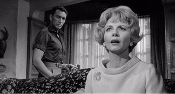 Movie still from “Night of the Eagle” (1962), directed by Sidney Hayers – An old photo of a man and a woman looking at each other; Medium shot, Low angle