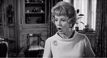 Movie still from “Night of the Eagle” (1962), directed by Sidney Hayers – An old black and white photo of a woman; Close Up shot, Over the shoulder angle