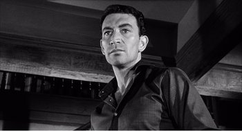Movie still from “Night of the Eagle” (1962), directed by Sidney Hayers – Black and white photograph of a man wearing a shirt and tie; Close Up shot, Low angle