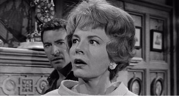 Movie still from “Night of the Eagle” (1962), directed by Sidney Hayers – An old photo of a man and a woman looking surprised; Close Up shot, Low angle