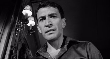Movie still from “Night of the Eagle” (1962), directed by Sidney Hayers – Black and white photograph of a man in a dark room; Close Up shot, Low angle