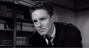 Movie still from “Night of the Eagle” (1962), directed by Sidney Hayers – A black and white photo of a man in a suit and tie; Close Up shot, Low angle