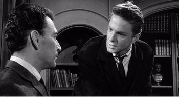 Movie still from “Night of the Eagle” (1962), directed by Sidney Hayers – A man in a suit and tie talking to another man in a suit and tie; Close Up shot, Over the shoulder angle