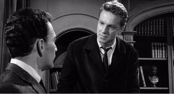 Movie still from “Night of the Eagle” (1962), directed by Sidney Hayers – A man in a suit and tie talking to another man in a suit and tie; Medium shot, Over the shoulder angle