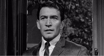 Movie still from “Night of the Eagle” (1962), directed by Sidney Hayers – Black and white photograph of a man wearing a suit and tie; Close Up shot, High angle