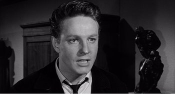 Movie still from “Night of the Eagle” (1962), directed by Sidney Hayers – A black and white photo of a man in a suit and tie; Close Up shot, Low angle