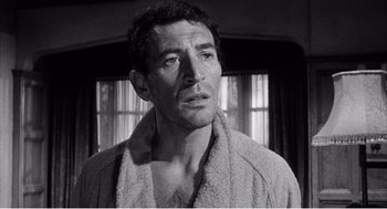 Movie still from “Night of the Eagle” (1962), directed by Sidney Hayers – Black and white photograph of a man in a bathrobe; Close Up shot, Low angle