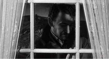 Movie still from “Night of the Eagle” (1962), directed by Sidney Hayers – A black and white photo of a man looking through a window; Close Up shot, Over the shoulder angle